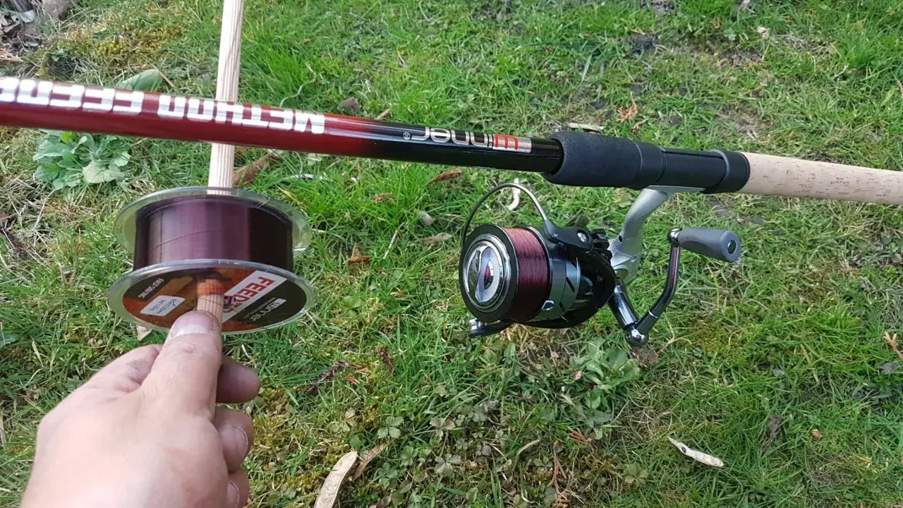 Wędka method feeder z kołowrotkiem i nową żyłką na trawie. Idealna żyłka do method feeder to podstawa udanego połowu.