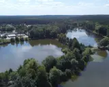 Malownicze jezioro Blachownia otoczone lasem, z widocznymi budynkami i drogami.