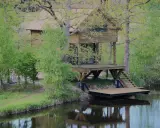 Drewniany domek na wodzie, idealne miejsce na agroturystykę z wędkowaniem.