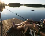 Relaks na pomoście nad jeziorem Wysoka. Słońce zachodzi, a wędkarz czeka na branie.