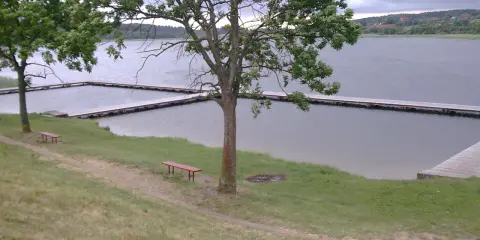 Olsztynek jezioro z drewnianymi pomostami i ławkami zaprasza do odpoczynku.