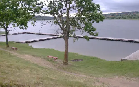 Olsztynek jezioro z drewnianymi pomostami i ławkami zaprasza do odpoczynku.