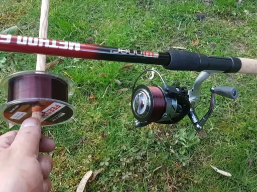 Wędka method feeder z kołowrotkiem i nową żyłką na trawie. Idealna żyłka do method feeder to podstawa udanego połowu.