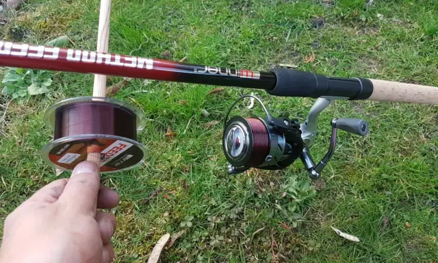 Wędka method feeder z kołowrotkiem i nową żyłką na trawie. Idealna żyłka do method feeder to podstawa udanego połowu.